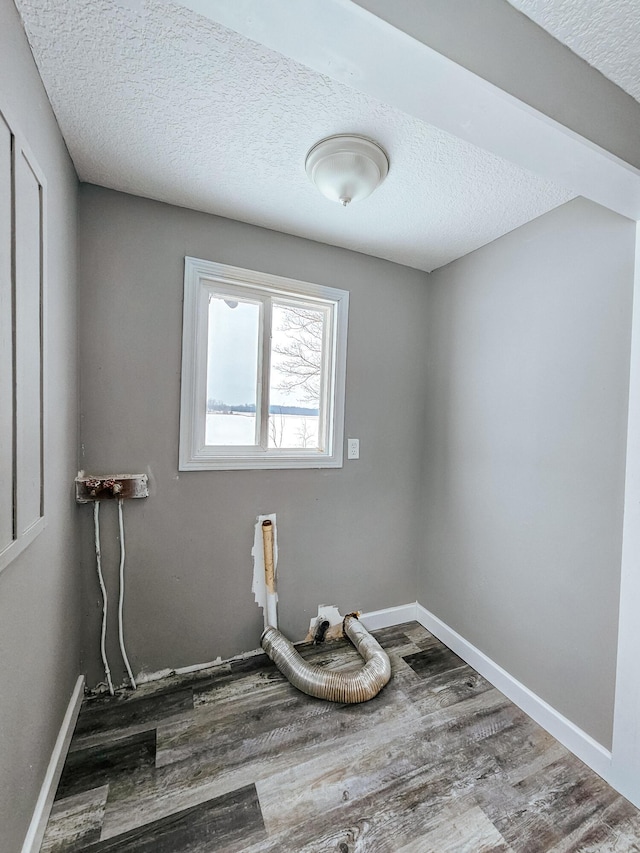 empty room with wood-type flooring and a textured ceiling