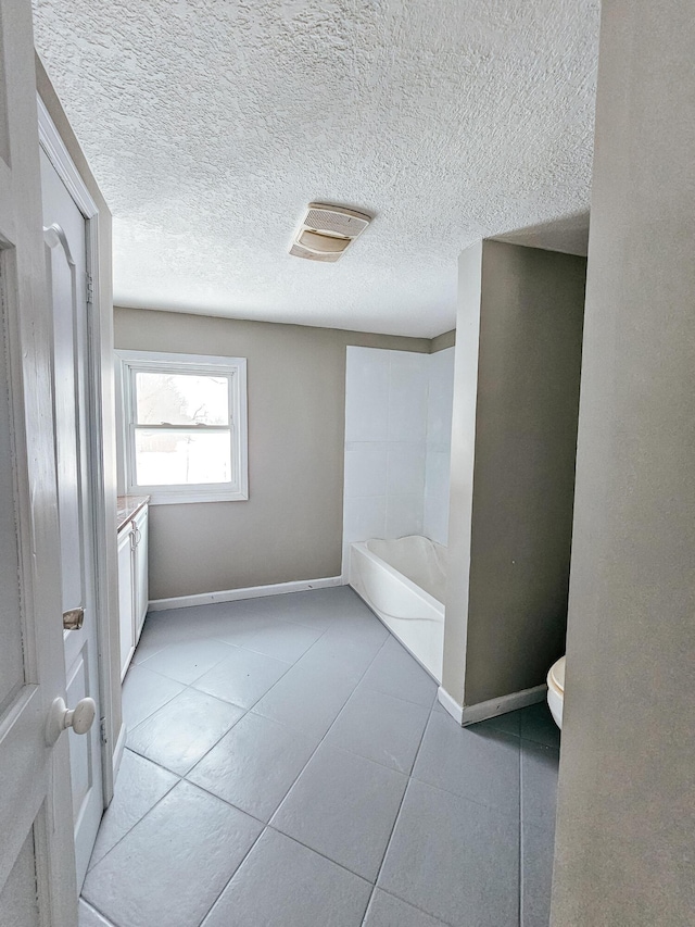 bathroom with a washtub, tile patterned floors, toilet, and vanity