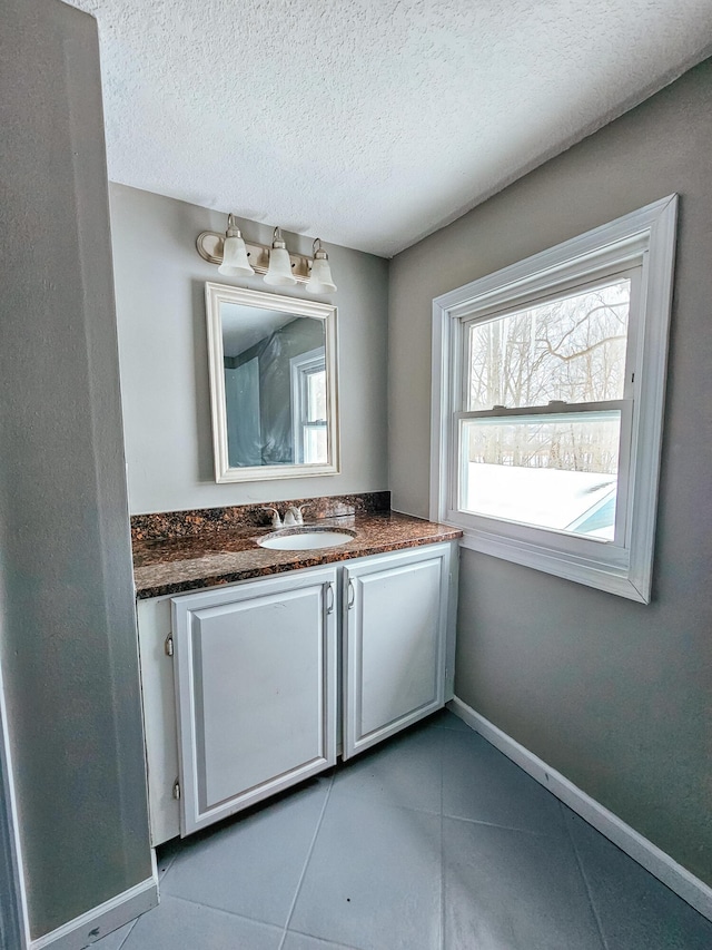 bathroom featuring vanity, tile patterned flooring, and a textured ceiling