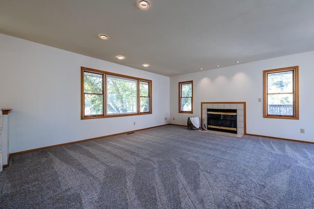 unfurnished living room with a tiled fireplace and carpet floors