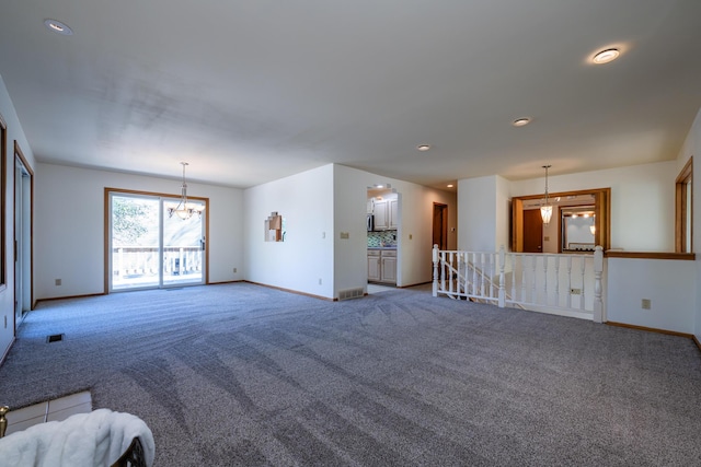 unfurnished living room featuring carpet floors and a chandelier