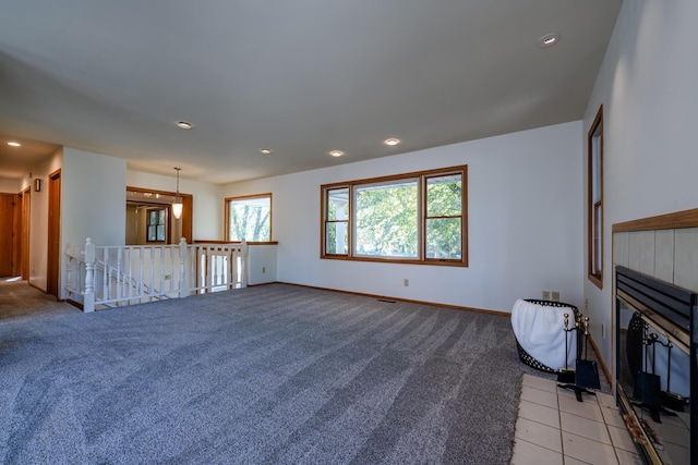 unfurnished living room featuring light colored carpet and a fireplace