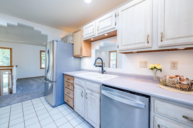 kitchen featuring appliances with stainless steel finishes, light colored carpet, and sink