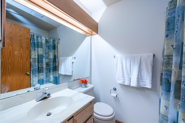 bathroom featuring toilet, vanity, and a shower with shower curtain