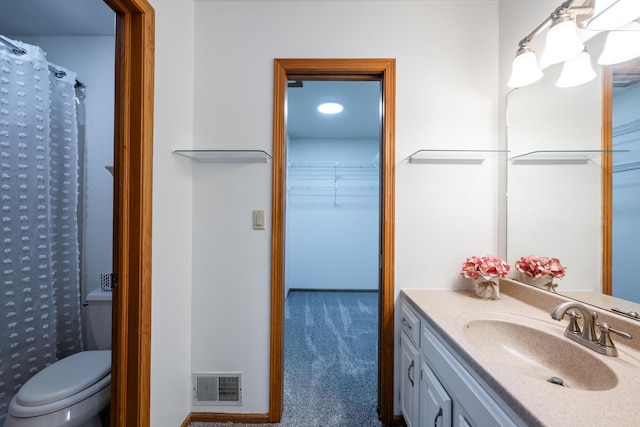 bathroom featuring toilet, vanity, and curtained shower