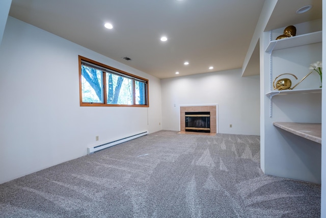 unfurnished living room with baseboard heating, carpet flooring, and a tiled fireplace