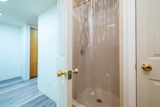 bathroom with a shower with shower curtain and hardwood / wood-style floors