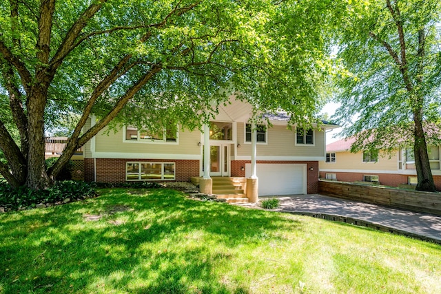 raised ranch with a garage and a front lawn