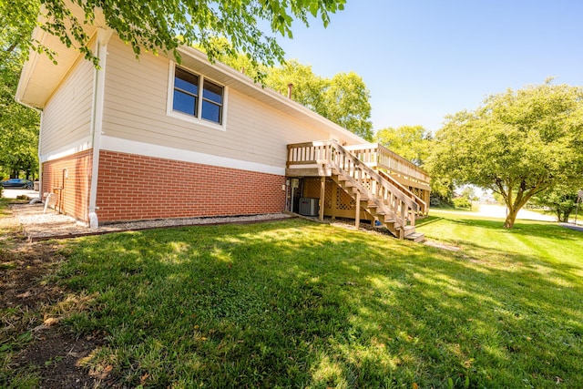 rear view of house featuring a deck, central air condition unit, and a lawn