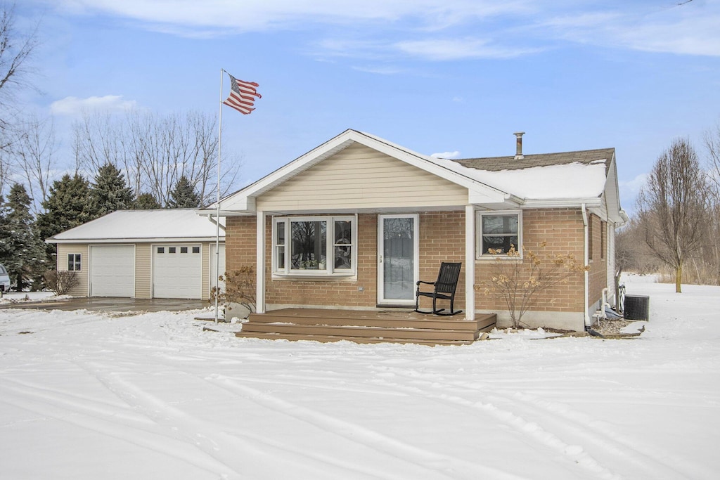 view of front of property featuring a garage and cooling unit