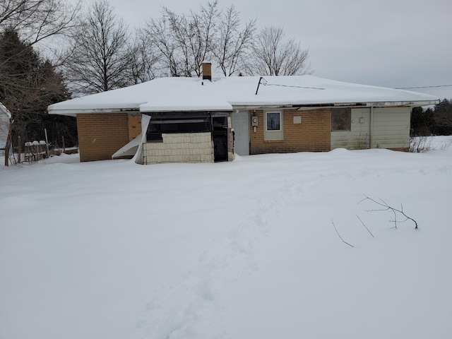 view of snow covered back of property