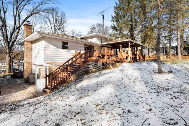 back of property featuring a chimney, stairway, and brick siding