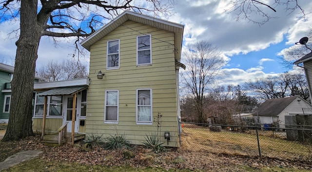 view of property exterior featuring a sunroom and fence