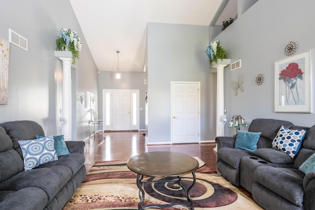 living room featuring decorative columns, high vaulted ceiling, and hardwood / wood-style floors