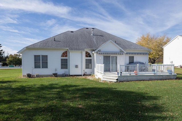 rear view of property with a deck and a yard