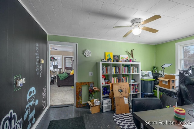 playroom featuring ceiling fan and wooden walls