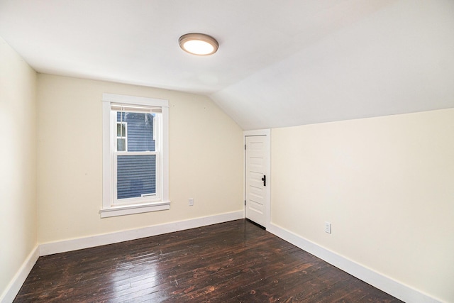 additional living space featuring lofted ceiling and dark wood-type flooring