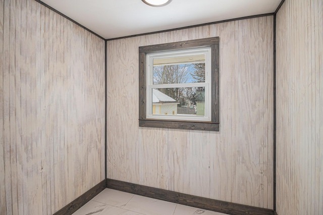 unfurnished room featuring wooden walls