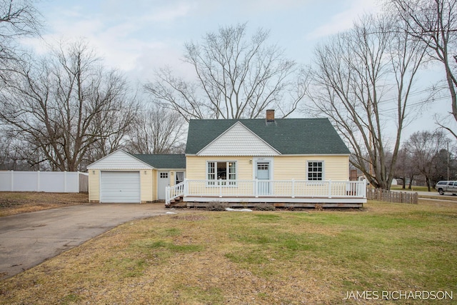 view of front of house with a deck, a front lawn, aphalt driveway, fence, and a chimney