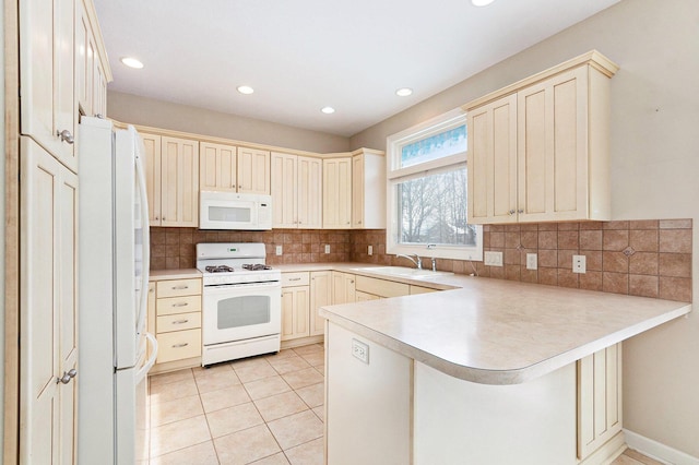 kitchen with light tile patterned floors, white appliances, a kitchen bar, decorative backsplash, and kitchen peninsula