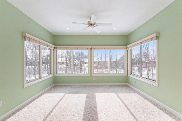 unfurnished sunroom featuring ceiling fan