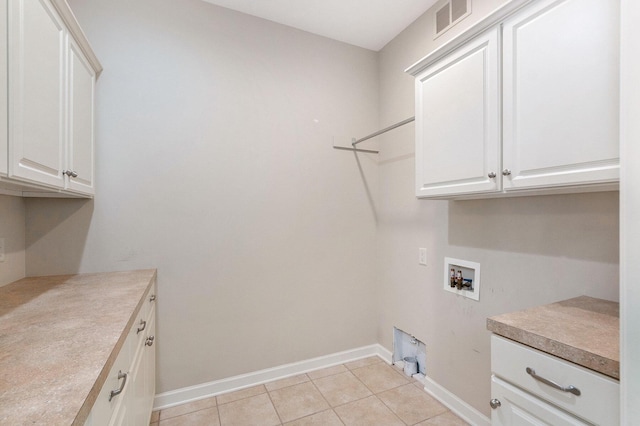 clothes washing area featuring cabinets, light tile patterned flooring, and hookup for a washing machine