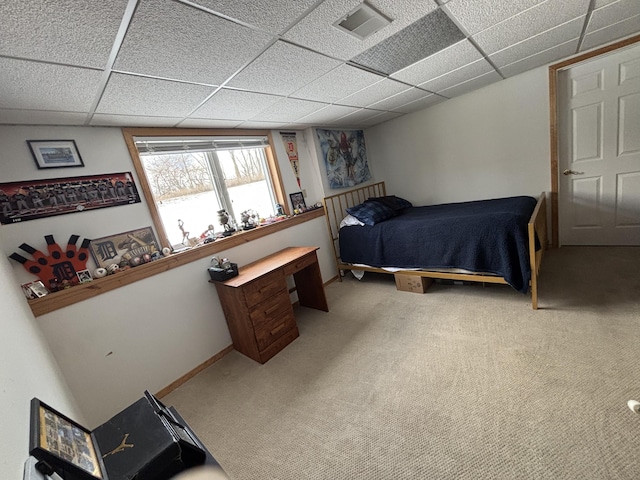 carpeted bedroom with a drop ceiling