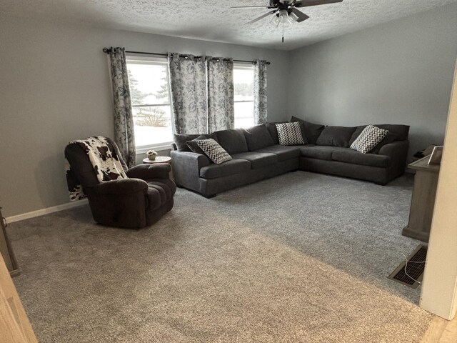 living room with carpet floors, ceiling fan, and a textured ceiling