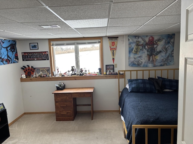 carpeted bedroom featuring a drop ceiling