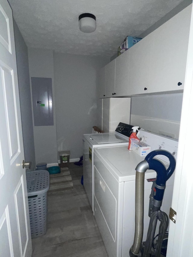 washroom featuring dark hardwood / wood-style floors, electric panel, separate washer and dryer, a textured ceiling, and cabinets