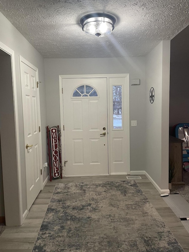 entrance foyer with a textured ceiling and hardwood / wood-style floors