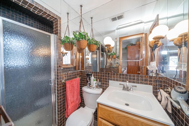 bathroom with tile walls, an enclosed shower, vanity, decorative backsplash, and toilet