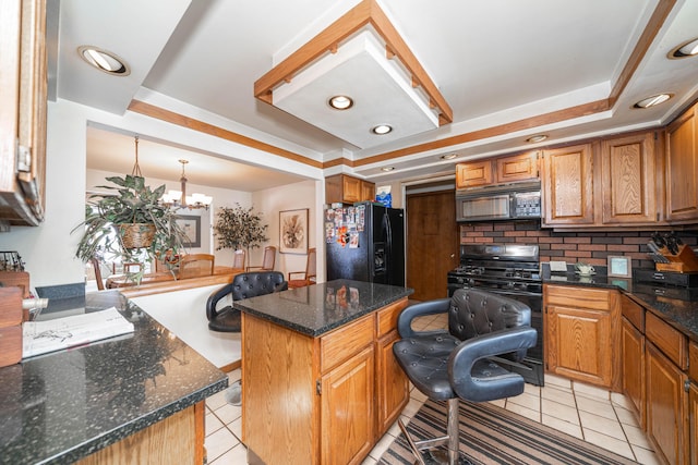 kitchen with light tile patterned floors, black appliances, a center island, and a breakfast bar