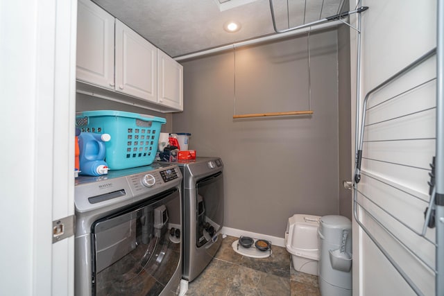 washroom featuring washer and clothes dryer and cabinets