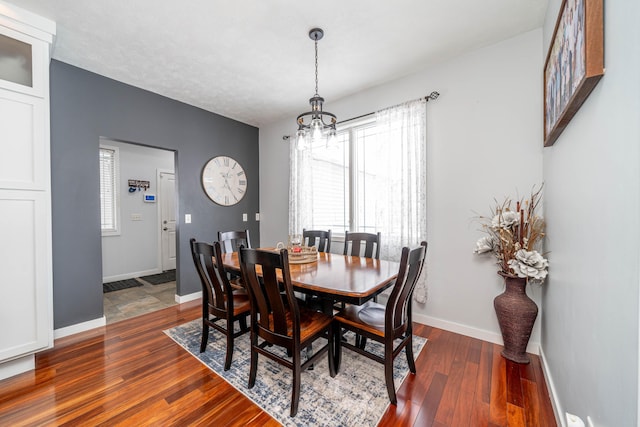 dining area with a healthy amount of sunlight, dark hardwood / wood-style flooring, and a chandelier