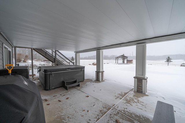 snow covered patio featuring area for grilling and a hot tub