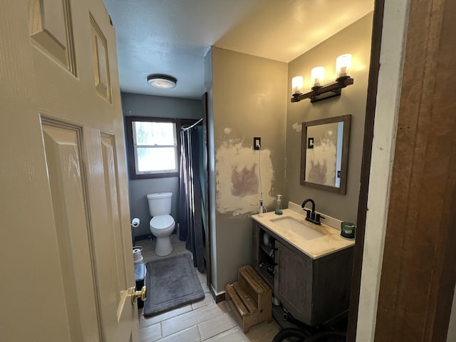 bathroom with tile patterned floors, toilet, vanity, and a shower with shower curtain