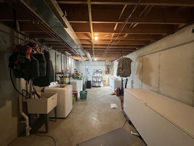 basement featuring sink, refrigerator, and washing machine and dryer