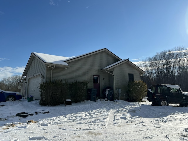 view of snow covered exterior featuring a garage