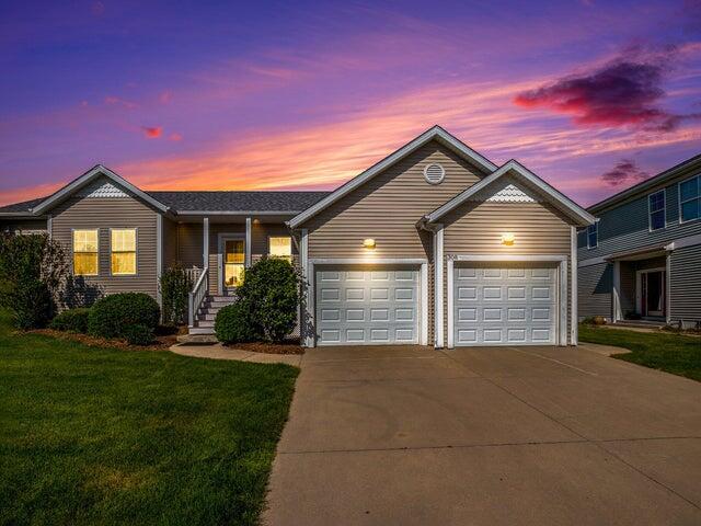 single story home featuring a lawn and a garage