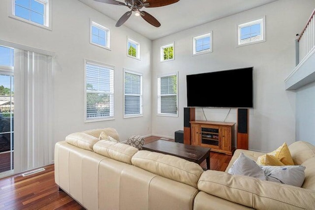 living room with dark wood-type flooring, plenty of natural light, and ceiling fan