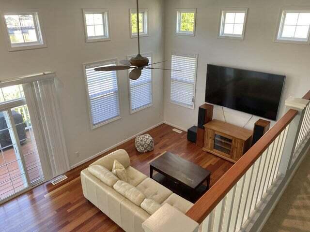 living room featuring ceiling fan, plenty of natural light, and dark wood-type flooring