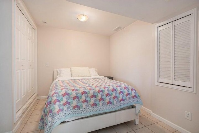 tiled bedroom with a closet