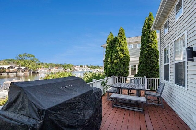 deck with area for grilling and a water view