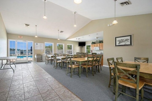 carpeted dining area featuring vaulted ceiling