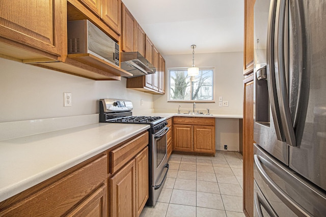 kitchen with sink, decorative light fixtures, light tile patterned floors, and appliances with stainless steel finishes