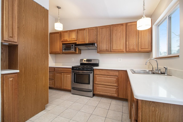 kitchen with sink, gas range, vaulted ceiling, and hanging light fixtures