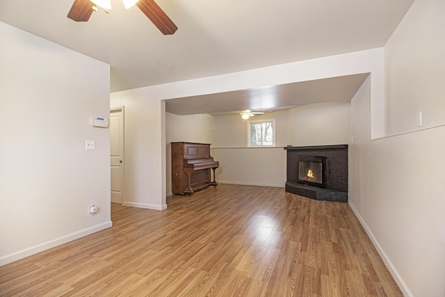 unfurnished living room featuring ceiling fan, a fireplace, and light hardwood / wood-style flooring