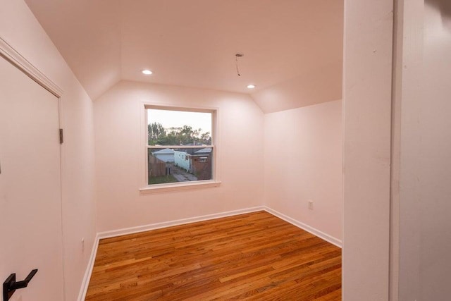 additional living space with vaulted ceiling and hardwood / wood-style floors