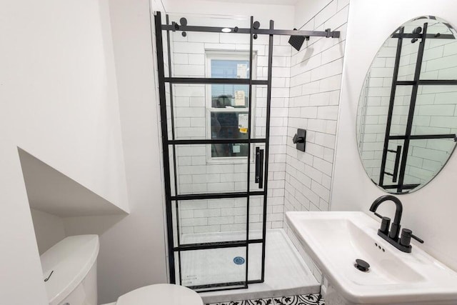 bathroom with toilet, sink, and tiled shower